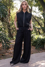 Pantalón de fit wide leg, cintura media con pretina, trabillas ajustables laterales, pinzas frontales, bolsillos delanteros y vivos decorativos posteriores. Cierre frontal con broche y cremallera ocultos.