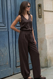Pantalón de fit wide leg, cintura alta con pretina, trabillas y lazo amarrable en cintura, pinzas frontales y bolsillos delanteros. Cierre frontal con broche y cremallera oculta.