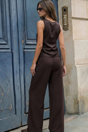 Pantalón de fit wide leg, cintura alta con pretina, trabillas y lazo amarrable en cintura, pinzas frontales y bolsillos delanteros. Cierre frontal con broche y cremallera oculta.