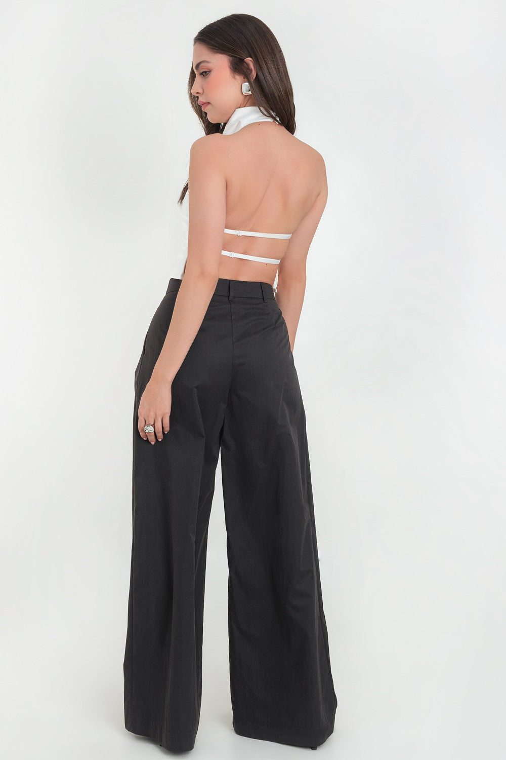 Pantalón de fit wide leg, cintura alta con pretina y trabillas, pinzas frontales, bolsillos delanteros, cierre frontal con botón y cremallera oculta.