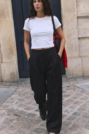 Pantalón de fit wide leg, cintura alta con pretina, pinzas frontales, bolsillos delanteros y vivos decorativos posteriores. Cierre frontal con broche y cremallera ocultos. Detalle v en pretina posterior.
