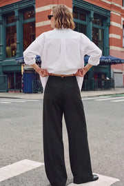 Pantalón de fit wide leg, cintura alta con pretina, pinzas frontales, bolsillos delanteros y vivos decorativos posteriores. Cierre frontal con broche y cremallera ocultos. Detalle v en pretina posterior.
