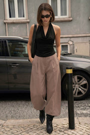 Pantalón de fit wide leg, cintura alta con pretina, pinzas frontales, bolsillos delanteros y vivos decorativos posteriores. Cierre frontal con broche y cremallera ocultos. Detalle v en pretina posterior.