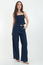 Pantalón de fit wide leg, cintura media con pretina y trabillas, pinzas frontales, vivo decorativo posterior, bolsillos delanteros, raya frontal y posterior. Cierre frontal con botón y cremallera oculta.