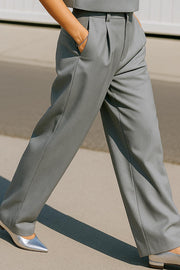Pantalón de fit wide leg, pinzas frontales, cintura alta con pretina y trabillas, bolsillos delanteros y posteriores con vivos. Cierre frontal con botón y cremallera oculta.