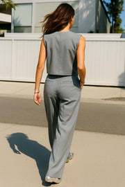 Pantalón de fit wide leg, pinzas frontales, cintura alta con pretina y trabillas, bolsillos delanteros y posteriores con vivos. Cierre frontal con botón y cremallera oculta.