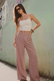 Pantalón de fit wide leg, cintura alta con pretina elástica posterior, trabillas, pinzas frontales y bolsillos delanteros.