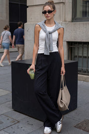 Pantalón de fit wide leg, cintura alta con pretina elástica posterior, trabillas, pinzas frontales y bolsillos delanteros.
