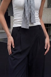 Pantalón de fit wide leg, cintura alta con pretina elástica posterior, trabillas, pinzas frontales y bolsillos delanteros.