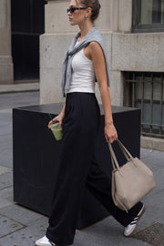 Pantalón de fit wide leg, cintura alta con pretina elástica posterior, trabillas, pinzas frontales y bolsillos delanteros.