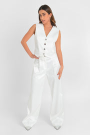Pantalón satinado de fit wide leg con pinzas frontales, cintura alta con pretina y trabillas, bolsillos delanteros, cierre frontal con botón en contraste y cremallera oculta.