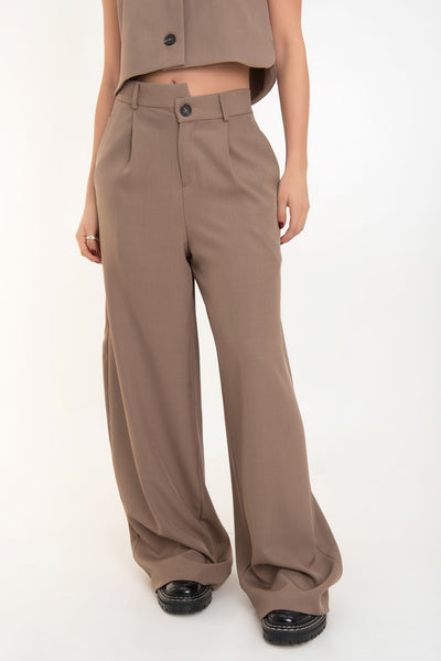 Pantalón de fit wide leg, cintura alta con pretina criss cross, trabillas, pinzas frontales con raya, bolsillos delanteros, cierre frontal con botón en contraste y cremallera oculta.