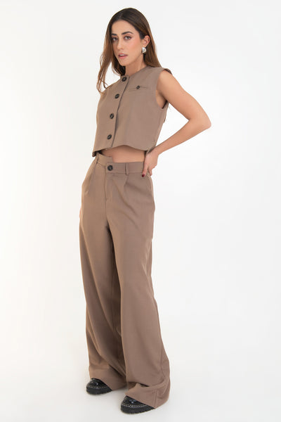 Pantalón de fit wide leg, cintura alta con pretina criss cross, trabillas, pinzas frontales con raya, bolsillos delanteros, cierre frontal con botón en contraste y cremallera oculta.