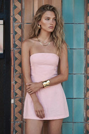 Playsuit strapless de fit ajustado, escote recto, pinzas frontales, lazo amarrable posterior y cierre con cremallera oculta.