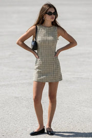 Playsuit de estampado cuadros, fit ajustado, cuello barco, sin mangas, pinzas frontales, lazo amarrable posterior y cierre con cremallera oculta.