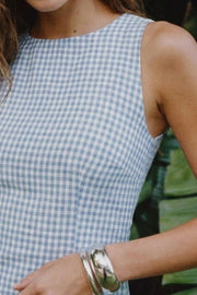 Playsuit de estampado cuadros, fit ajustado, cuello barco, sin mangas, pinzas frontales, lazo amarrable posterior y cierre con cremallera oculta.
