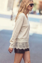 Suéter de punto, fit oversized, manga larga, cuello v, rib en bordes y detalle de encaje decorativo en bajo.