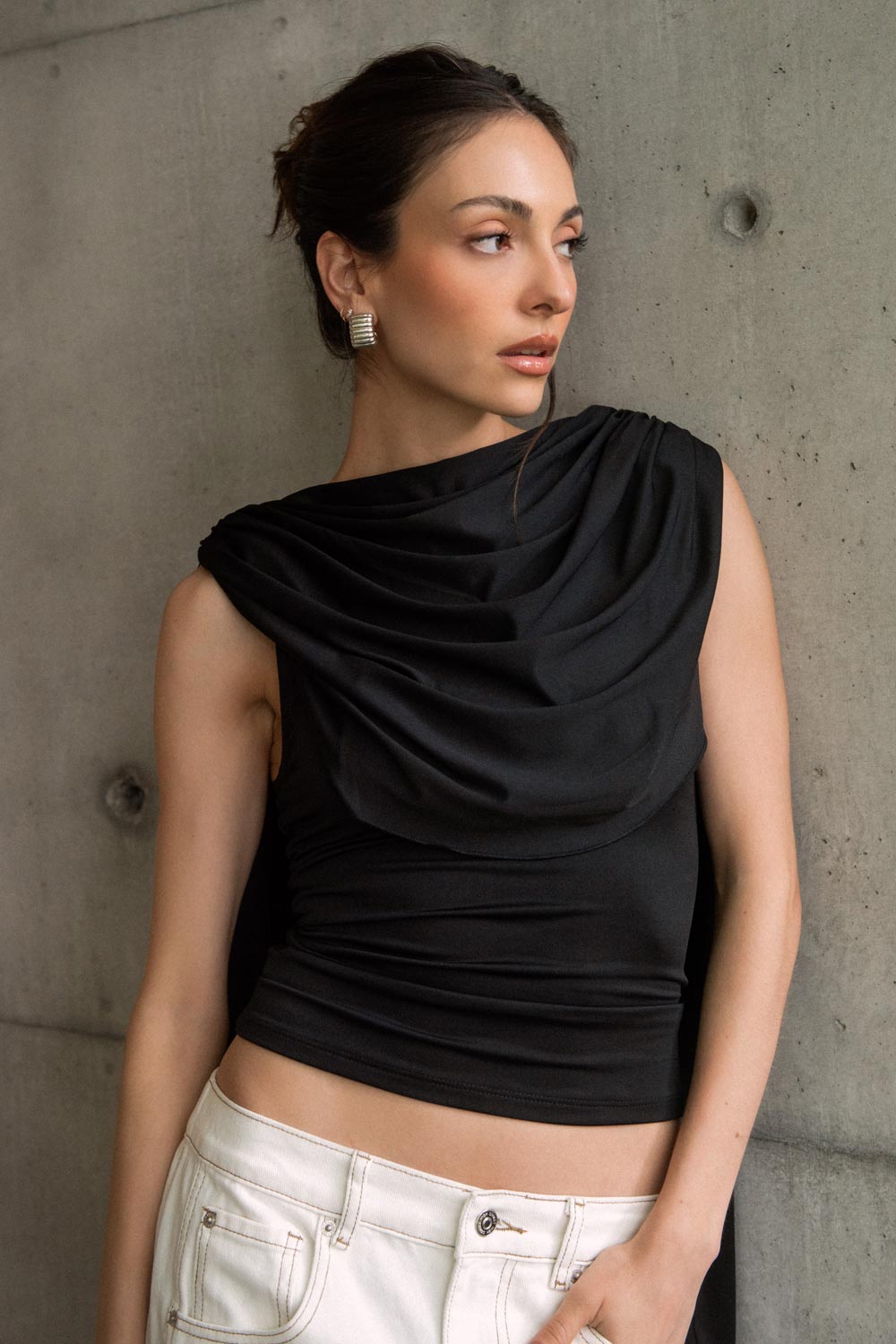 Top de fit ajustado, sin mangas, cuello redondo y detalle decorativo frontal con plisados en hombros.