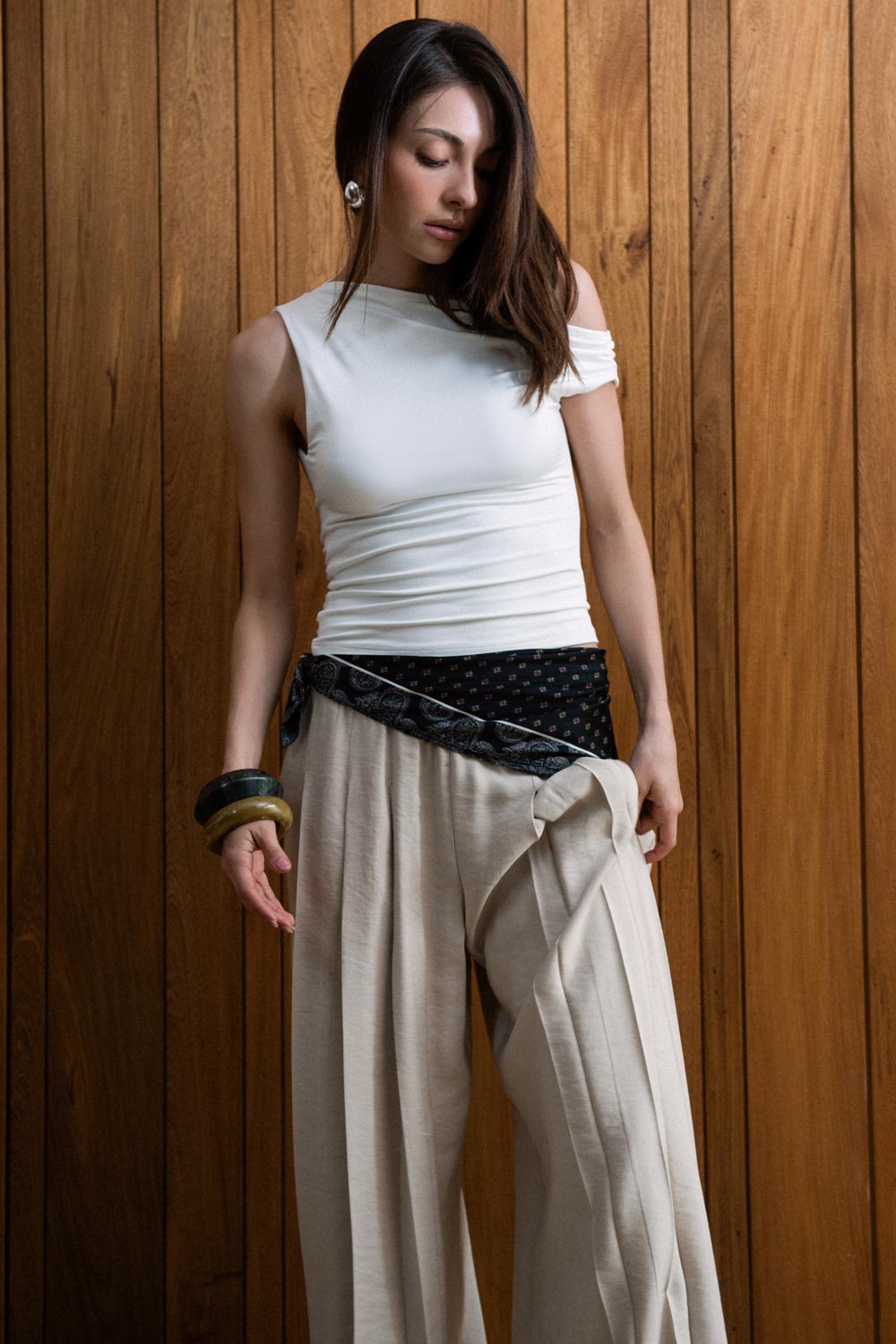 Top de fit ajustado, asimétrico de escote diagonal, una manga corta seguida con plisados y hombro descubierto. Detalle de escote en espalda.