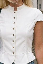 Top corto de fit ajustado, manga corta, cuello mao y cierre frontal con botones en contraste. Detalle de peplum con olanes y bajo curveado frontal.