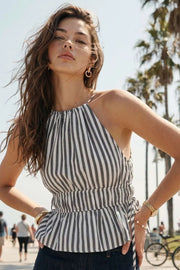 Top corto de estampado rayas, cuello halter con tirantes delgados, fit ajustado, rib con plisados en cintura y cuello. Detalle de jaretas ajustables en cintura, cierre posterior con botón y ojal.