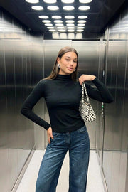 Top básico canalé de fit ajustado, cuello mock seguido y manga larga.