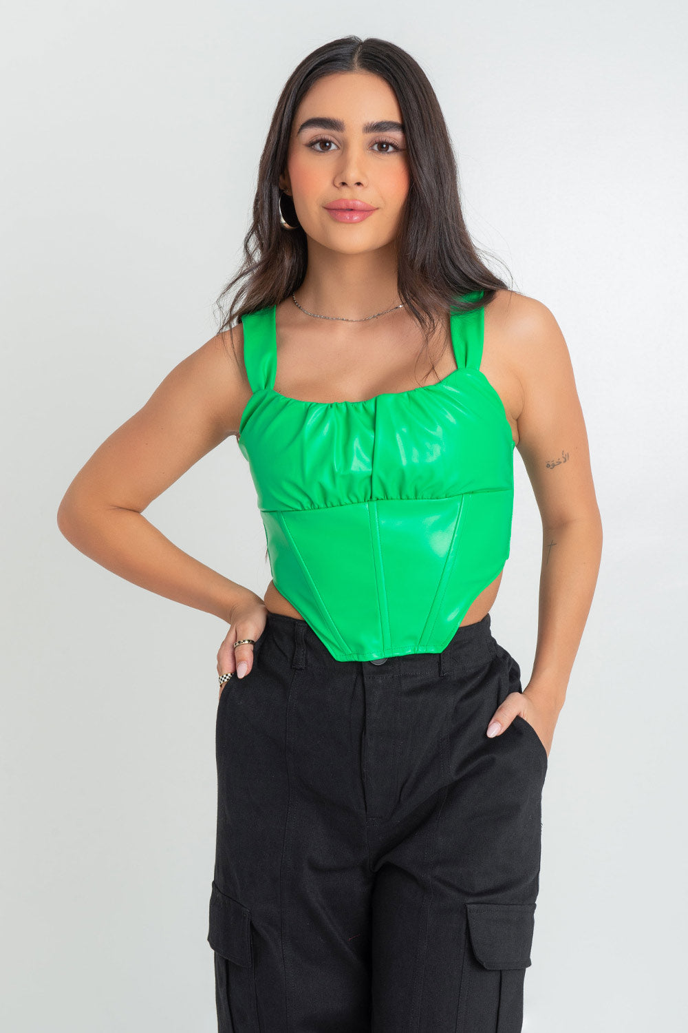 Top corset de fit ajustado, efecto piel, escote redondeado con detalles plisados, costuras frontales con varillas, tirantes y detalle de bajo curveado con cut outs laterales. Cierre posterior cremallera visible en contraste.