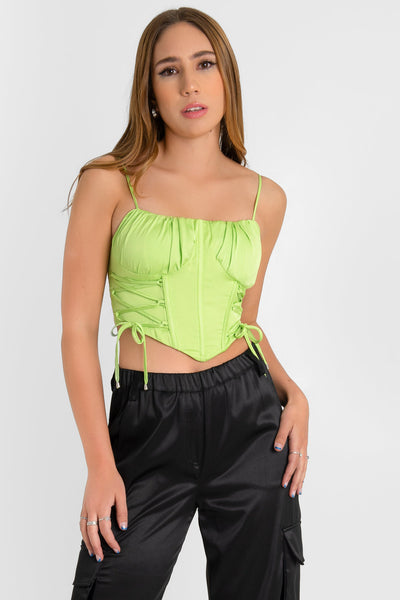 Top corset satinado de fit ajustado, tirantes delgados ajustables, escote recto con detalles plisados, costuras frontales decorativas de corset con lazados laterales y bajo v frontal. Cierre posterior con cremallera visible en contraste.