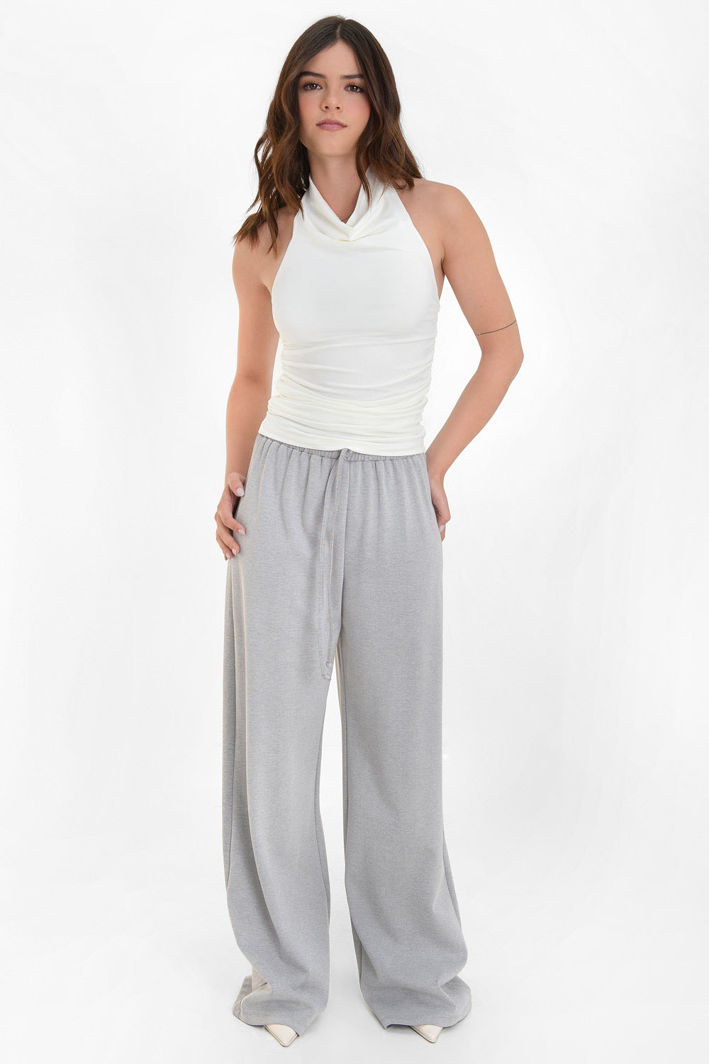 Top corto sin mangas, de fit ajustado, detalles plisados en costados, cuello halter fluido y escote en espalda.