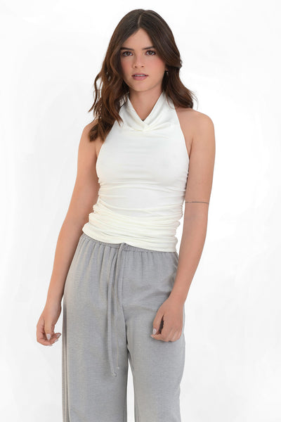 Top corto sin mangas, de fit ajustado, detalles plisados en costados, cuello halter fluido y escote en espalda.