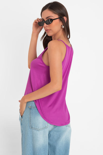 Top de cuello halter sin mangas, tirantes finos, bajo curveado y silueta ligeramente oversize.