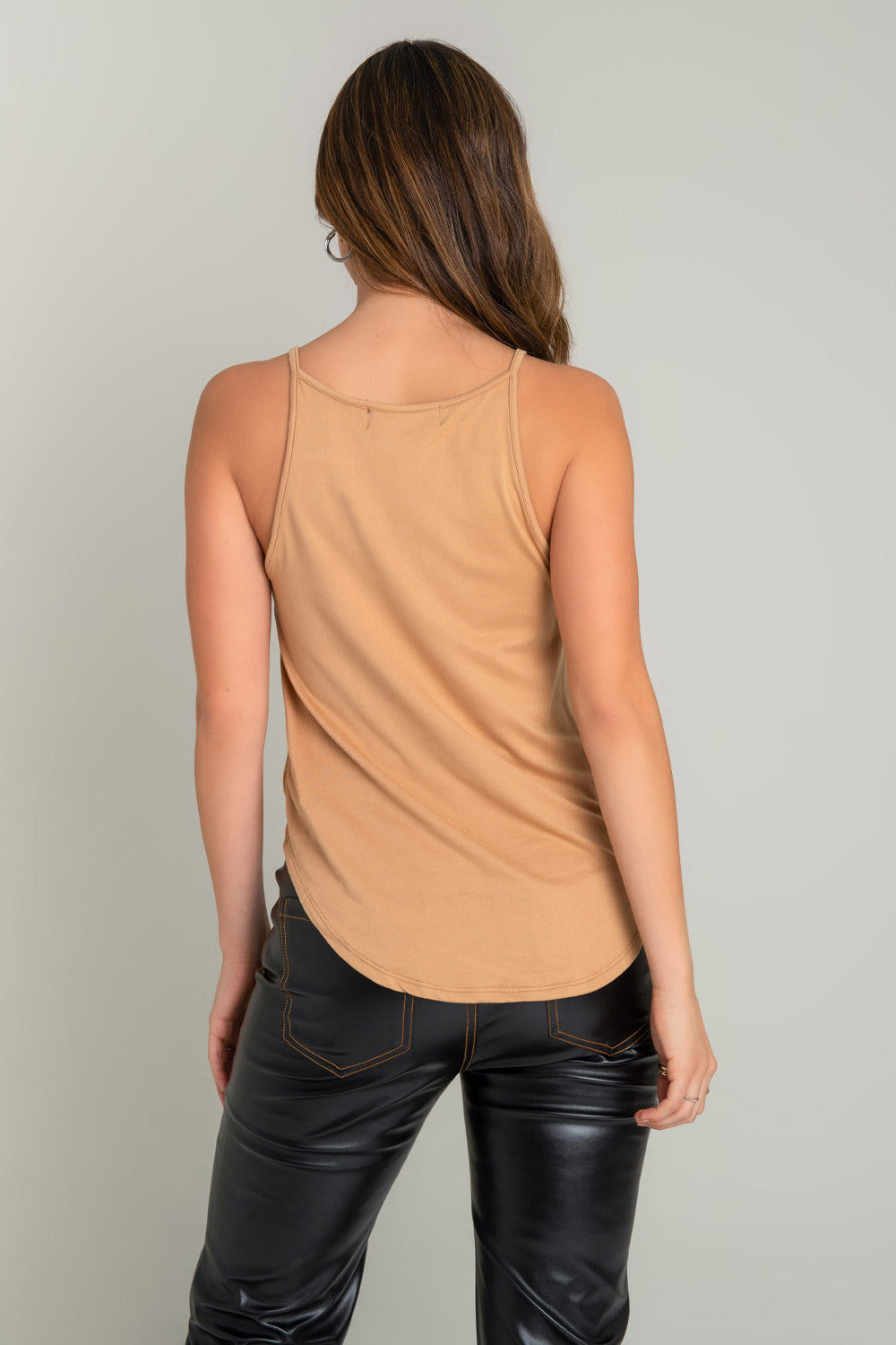 Top de cuello halter sin mangas, tirantes finos, bajo curveado y silueta ligeramente oversized.