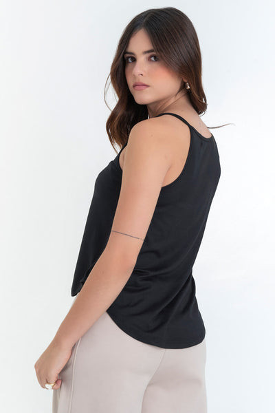 Top de cuello halter sin mangas, tirantes finos, bajo curveado y silueta ligeramente oversized.
