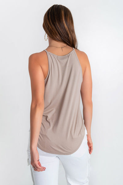 Top de cuello halter sin mangas, tirantes finos, bajo curveado y silueta ligeramente oversized.