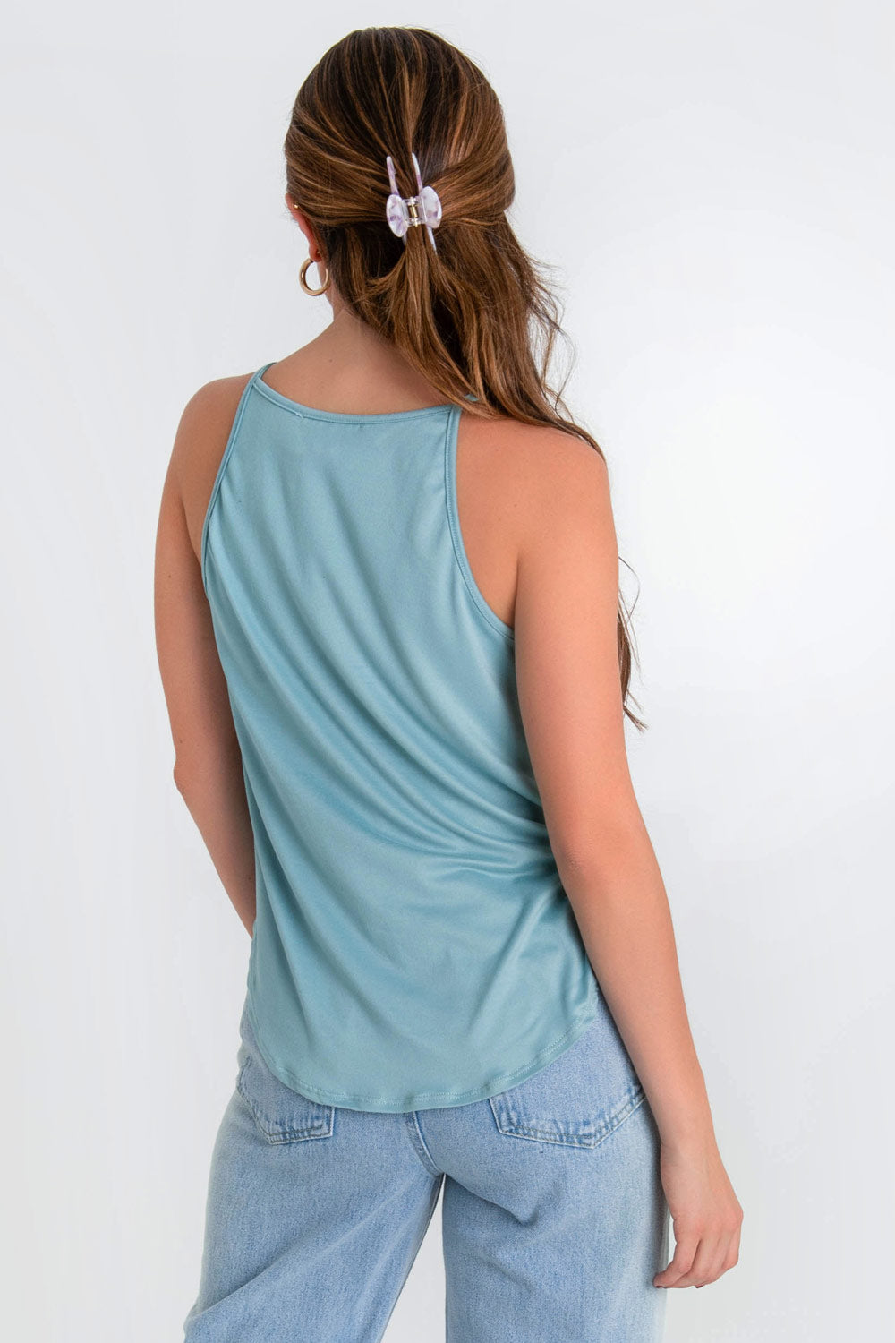 Top de cuello halter sin mangas, tirantes finos, bajo curveado y silueta ligeramente oversize.