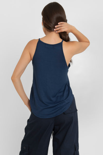 Top de cuello halter sin mangas, tirantes finos, bajo curveado y silueta ligeramente oversize.