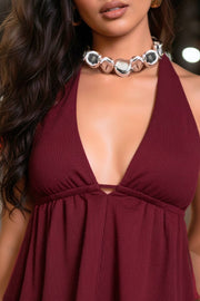 Top canalé de cuello halter con nudo amarrable posterior, escote v con plisados frontales, rib elástico en cintura y peplum olanes. Detalle de escote en espalda con lazo amarrable posterior.