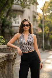 Top corto de estampado rayas, cuello halter con nudo amarrable posterior, escote v y plisados en cintura, fit ajustado, escote en espalda y cierre posterior con nudo amarrable.