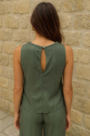 Top halter de fit recto, cuello fluido, sin mangas, cierre posterior con botón y ojal.