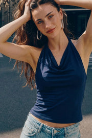 Top corto de cuello halter fluido, sin mangas, fit ajustado y escote en espalda.