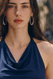 Top corto de cuello halter fluido, sin mangas, fit ajustado y escote en espalda.