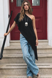 Blusa tipo túnica asimétrica, escote diagonal, una manga corta seguida con olanes, fit fluido y bajo asimétrico.