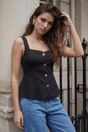 Top canalé de fit ajustado, sin mangas, escote cuadrado, cortes frontales y peplum con olanes en bajo. Cierre frontal con hilera de botones en contraste.