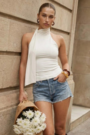 Top de fit ajustado, sin mangas, escote en espalda, cuello halter con plisados y nudo amarrable.