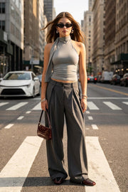 Top de fit ajustado, sin mangas, escote en espalda, cuello halter con plisados y nudo amarrable.