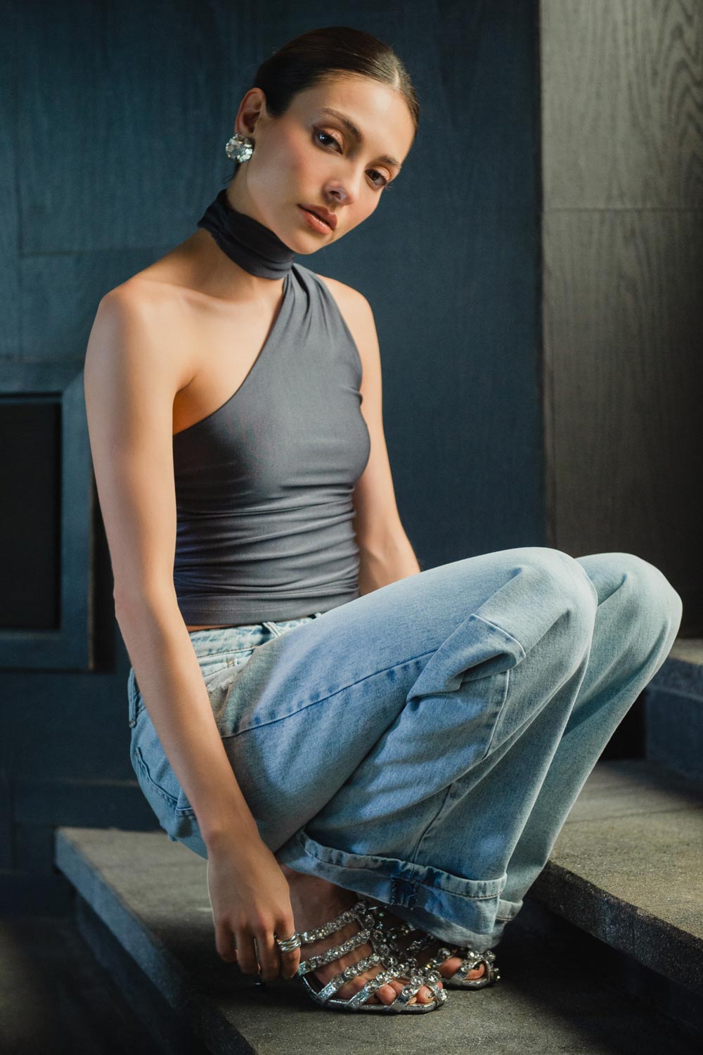 Top satinado asimétrico, de fit ajustado, detalles plisados laterales y en hombro, sin mangas, un hombro, escote diagonal y choker con plisados. Cierre posterior con botón y ojal.