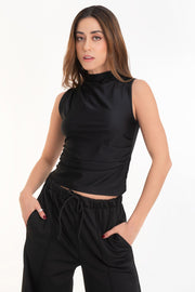 Top satinado de fit ajustado, cuello mock seguido con plisados en un hombro, sin mangas y plisados decorativos en costados.