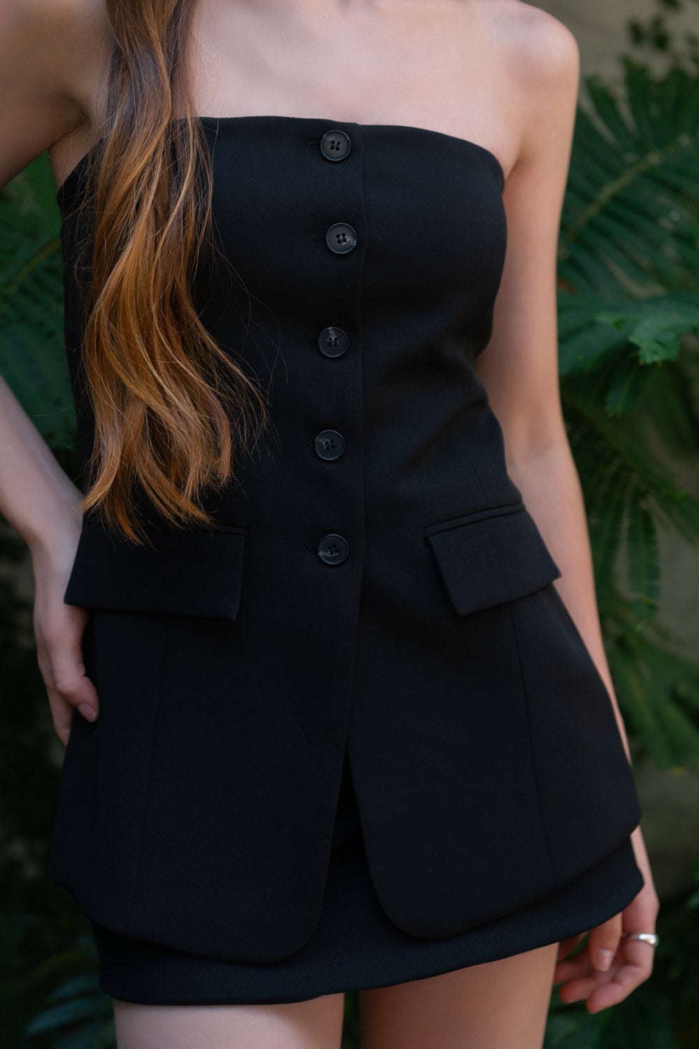 Top strapless de fit ajustado, corte en a, escote recto, bolsillos decorativos frontales con cartera y cierre frontal con hilera de botones en contraste.