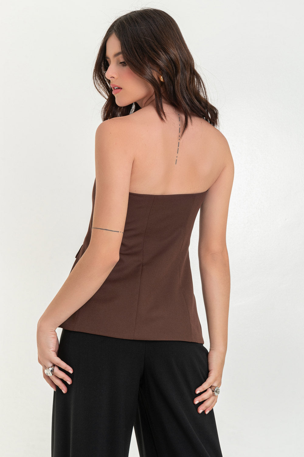 Top strapless de fit ajustado, corte en a, escote recto, bolsillos decorativos frontales con cartera y cierre frontal con hilera de botones en contraste.