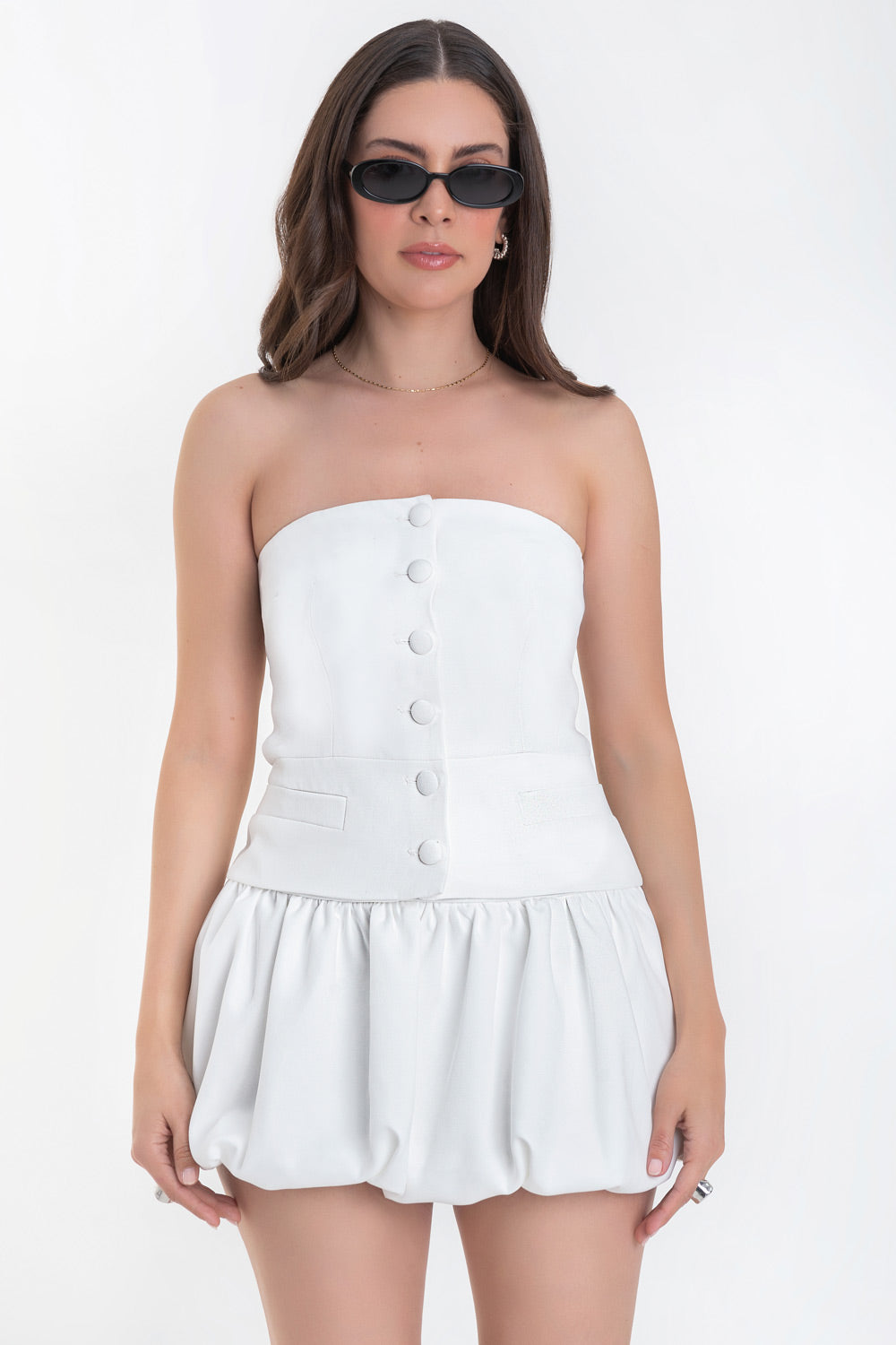 Top tubo de fit ajustado, strapless, escote recto, corte en cintura, vivos decorativos y cierre frontal con hilera de botones forrados.